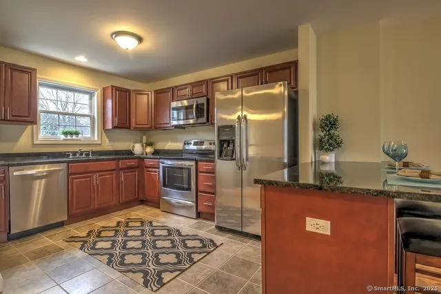a kitchen with stainless steel appliances granite countertop a sink stove and refrigerator