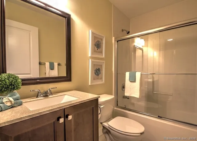 a bathroom with a granite countertop sink toilet a mirror a vanity and shower