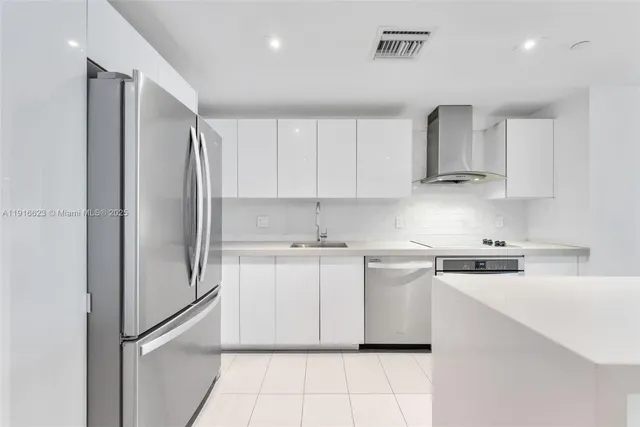 a kitchen with stainless steel appliances a refrigerator sink and cabinets