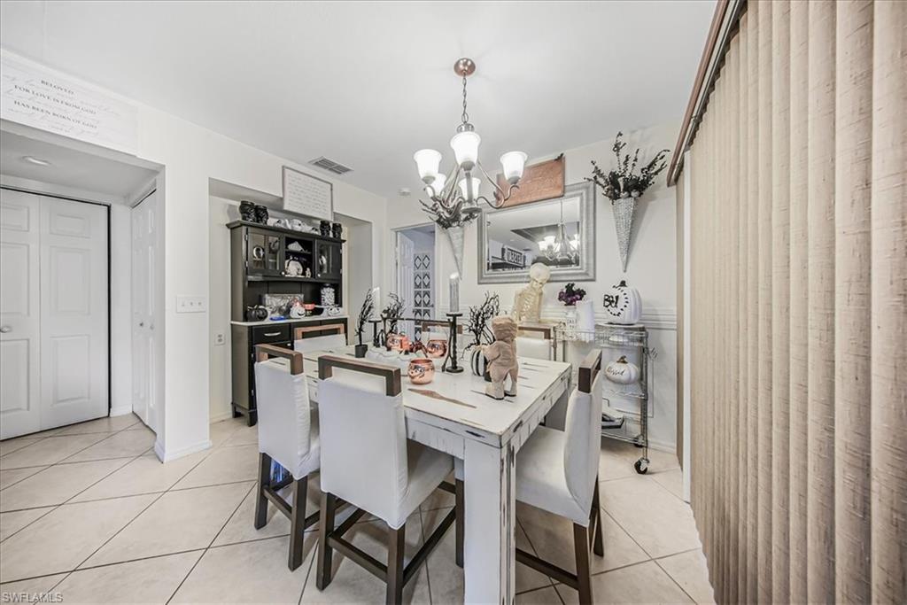 3408 Timberwood Circle, Unit 1360 Naples, FL 34105 - Photo 14 of 36 a view of a dining room with furniture and chandelier