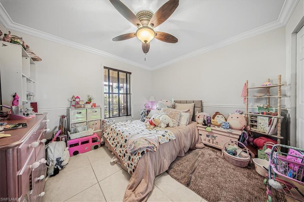 3408 Timberwood Circle, Unit 1360 Naples, FL 34105 - Photo 20 of 36 a bedroom with bed and a chandelier