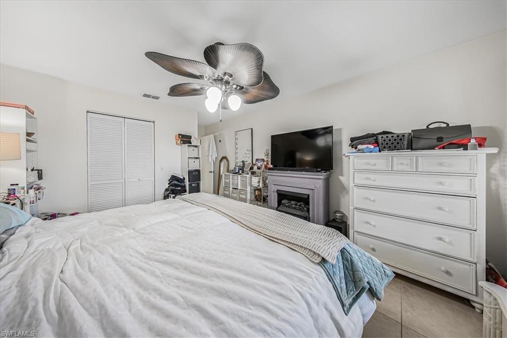 3408 Timberwood Circle, Unit 1360 Naples, FL 34105 - Photo 22 of 36 a bedroom with a bed and a flat screen tv