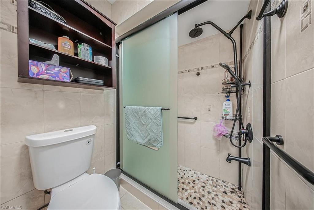 3408 Timberwood Circle, Unit 1360 Naples, FL 34105 - Photo 25 of 36 a bathroom with a toilet and a shower