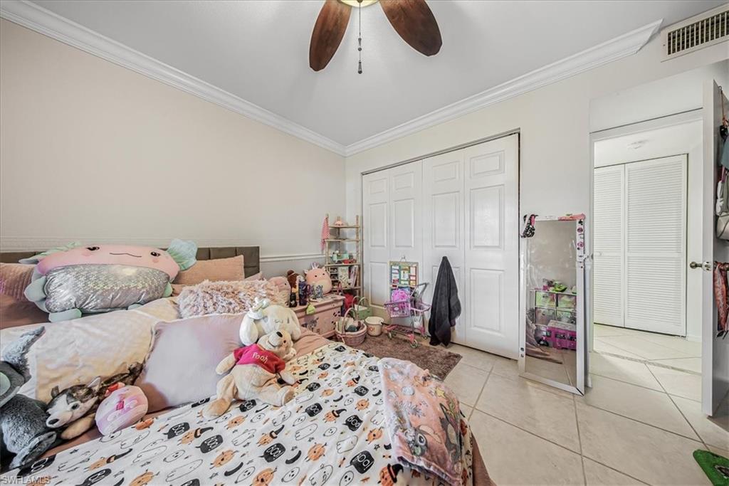 3408 Timberwood Circle, Unit 1360 Naples, FL 34105 - Photo 27 of 36 a bed room with a bed and a chandelier