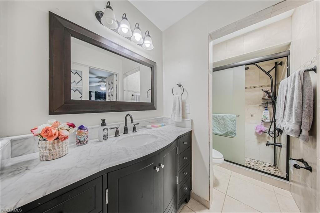 3408 Timberwood Circle, Unit 1360 Naples, FL 34105 - Photo 28 of 36 a bathroom with a sink mirror and vanity