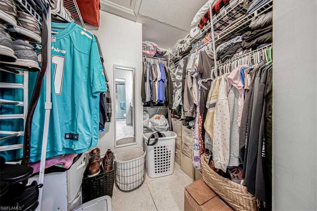 3408 Timberwood Circle, Unit 1360 Naples, FL 34105 - Photo 31 of 36 a view of walk in closet with clothes and shoes