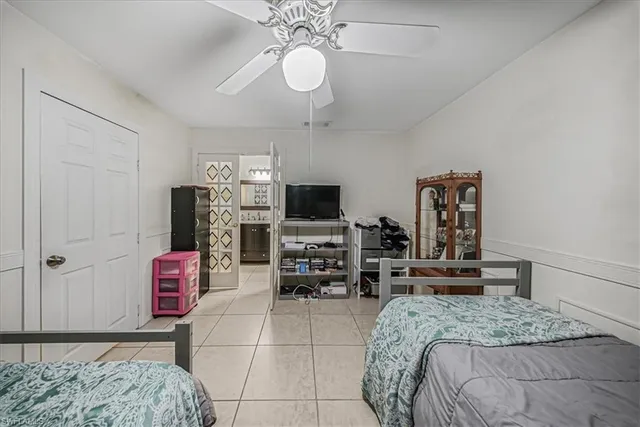 a bedroom with a bed a flat screen tv and chandelier