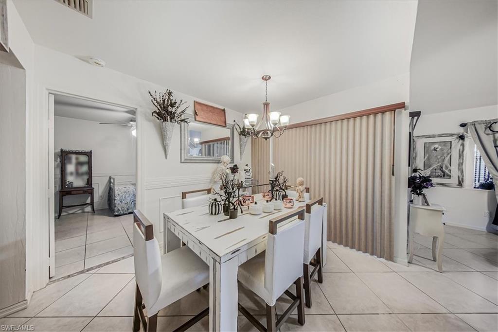 3408 Timberwood Circle, Unit 1360 Naples, FL 34105 - Photo 7 of 36 a view of a dining room with furniture and chandelier