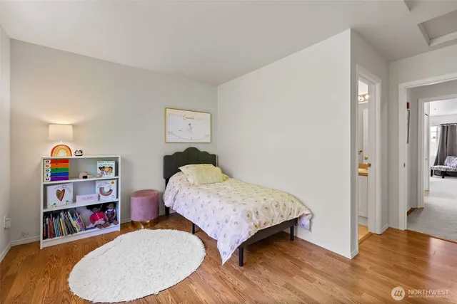 a bedroom with bed and wooden floor