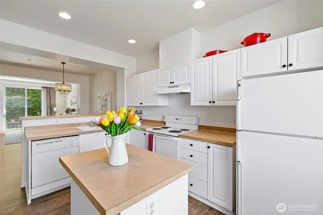a kitchen with a white refrigerator a white cabinets and a stove