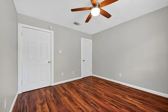 an empty room with closet and ceiling fan