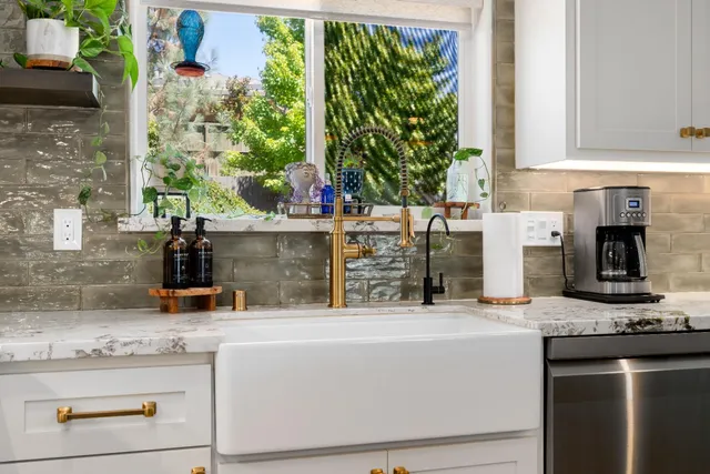 a kitchen with granite countertop a stove oven and white cabinets