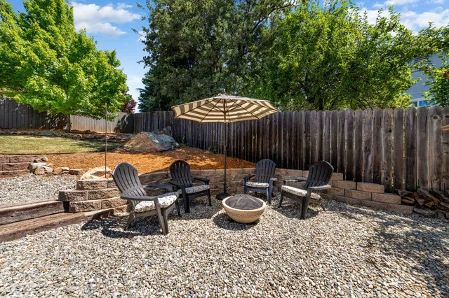 a view of a patio with table and chairs with wooden fence and plants