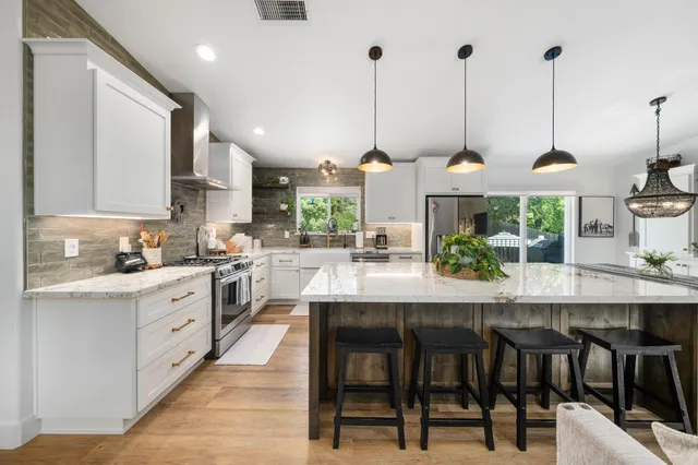a living room with stainless steel appliances kitchen island granite countertop furniture and a view of kitchen