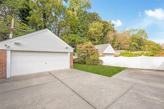 a view of white house with a garage and a yard
