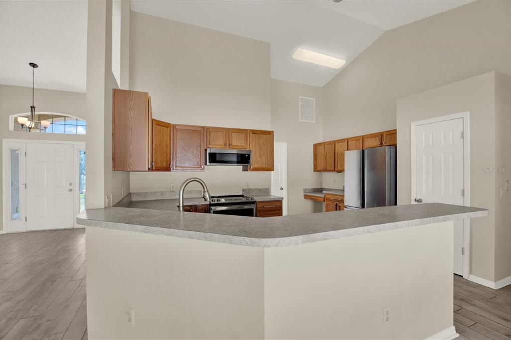 4400 Dior Road Spring Hill, FL 34609 - Photo 13 of 37 a kitchen with stainless steel appliances a sink a stove a microwave a refrigerator a counter top space and cabinets
