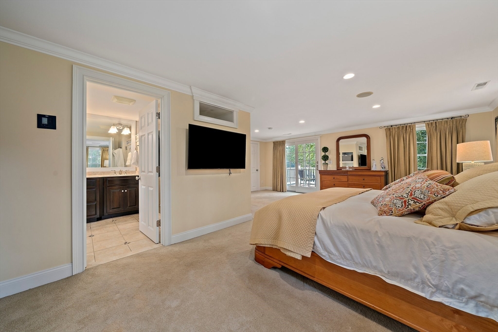 21 Old Coach Road Canton, MA 02021 - Photo 20 of 42 a spacious bedroom with a bed a mirror and tv