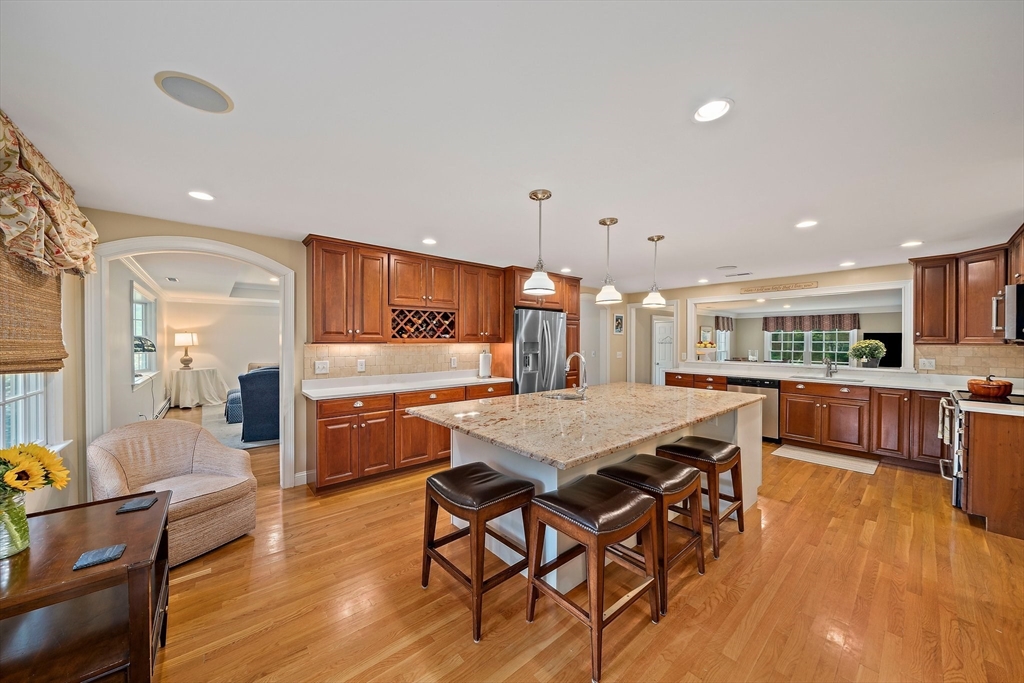 21 Old Coach Road Canton, MA 02021 - Photo 5 of 42 a kitchen with stainless steel appliances kitchen island granite countertop a table chairs and a refrigerator