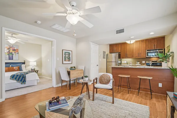 a living room with stainless steel appliances kitchen island granite countertop furniture and a couch