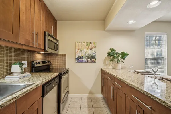 a kitchen with stainless steel appliances granite countertop a sink a stove and a microwave