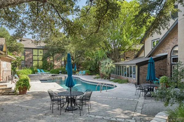 a view of a patio with table and chairs and potted plants with large tree