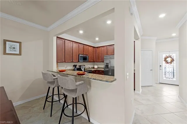 a kitchen with stainless steel appliances kitchen island granite countertop a refrigerator and a stove top oven