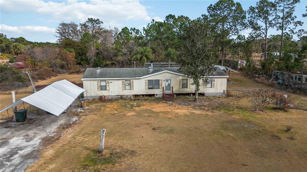2665 Absher Road St. Cloud, FL 34771 - Photo 13 of 27 a white house that has a tree in front of it