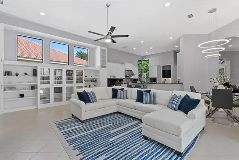 a living room with furniture kitchen view and a chandelier