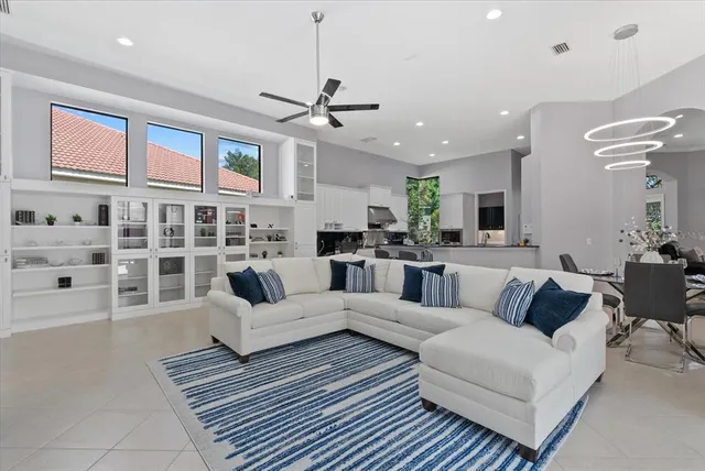a living room with furniture kitchen view and a chandelier