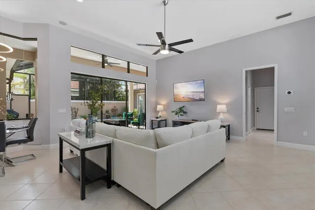 a living room with furniture a ceiling fan and a window