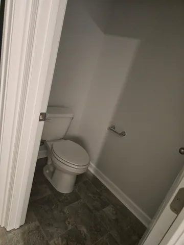 a white toilet sitting next to a small window