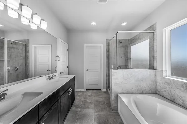 a spacious bathroom with a double vanity sink a large mirror and shower