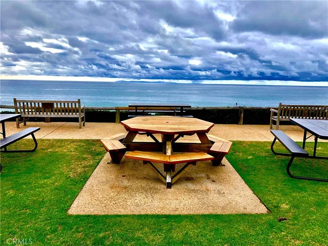 a wooden bench sitting in the grass near a building