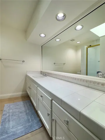 a bathroom with a sink a large mirror and a shower