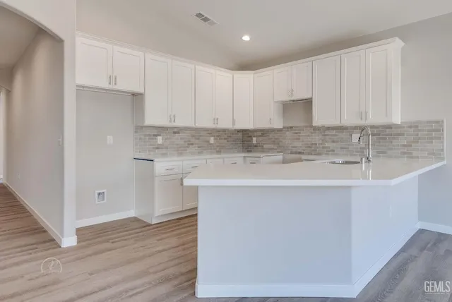 a kitchen with stainless steel appliances granite countertop a white stove top oven and white cabinets