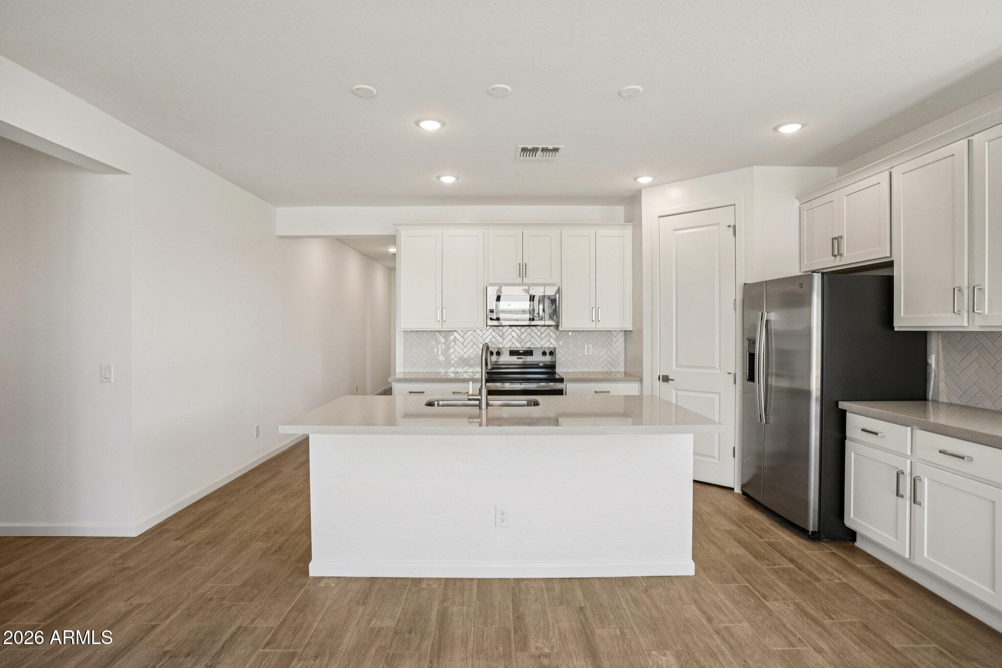 32094 Buckaroo Road San Tan Valley, AZ 85140 - Photo 9 of 46 a kitchen with stainless steel appliances a sink and a refrigerator