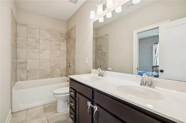 a bathroom with a sink a toilet a mirror a bathtub and shower