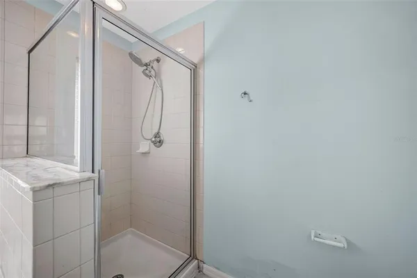 a bathroom with a granite countertop shower and a sink