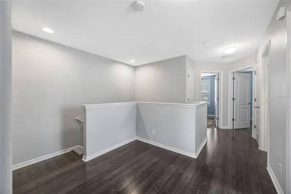 a view of an empty room with wooden floor