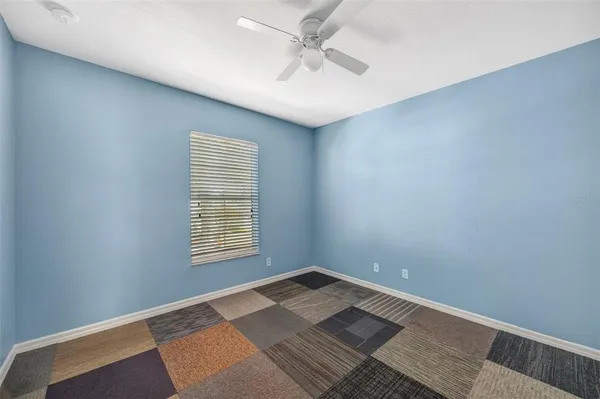 an empty room with a window and ceiling fan