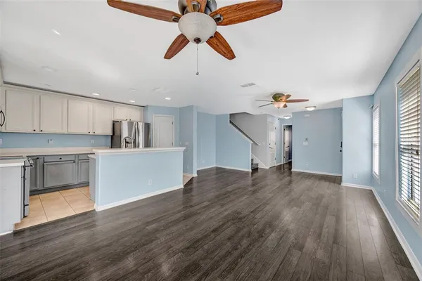 a view of empty room with wooden floor and ceiling fan
