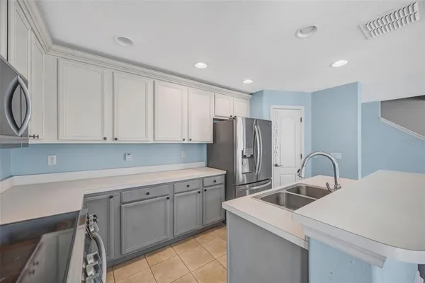a kitchen with a sink a refrigerator and cabinets