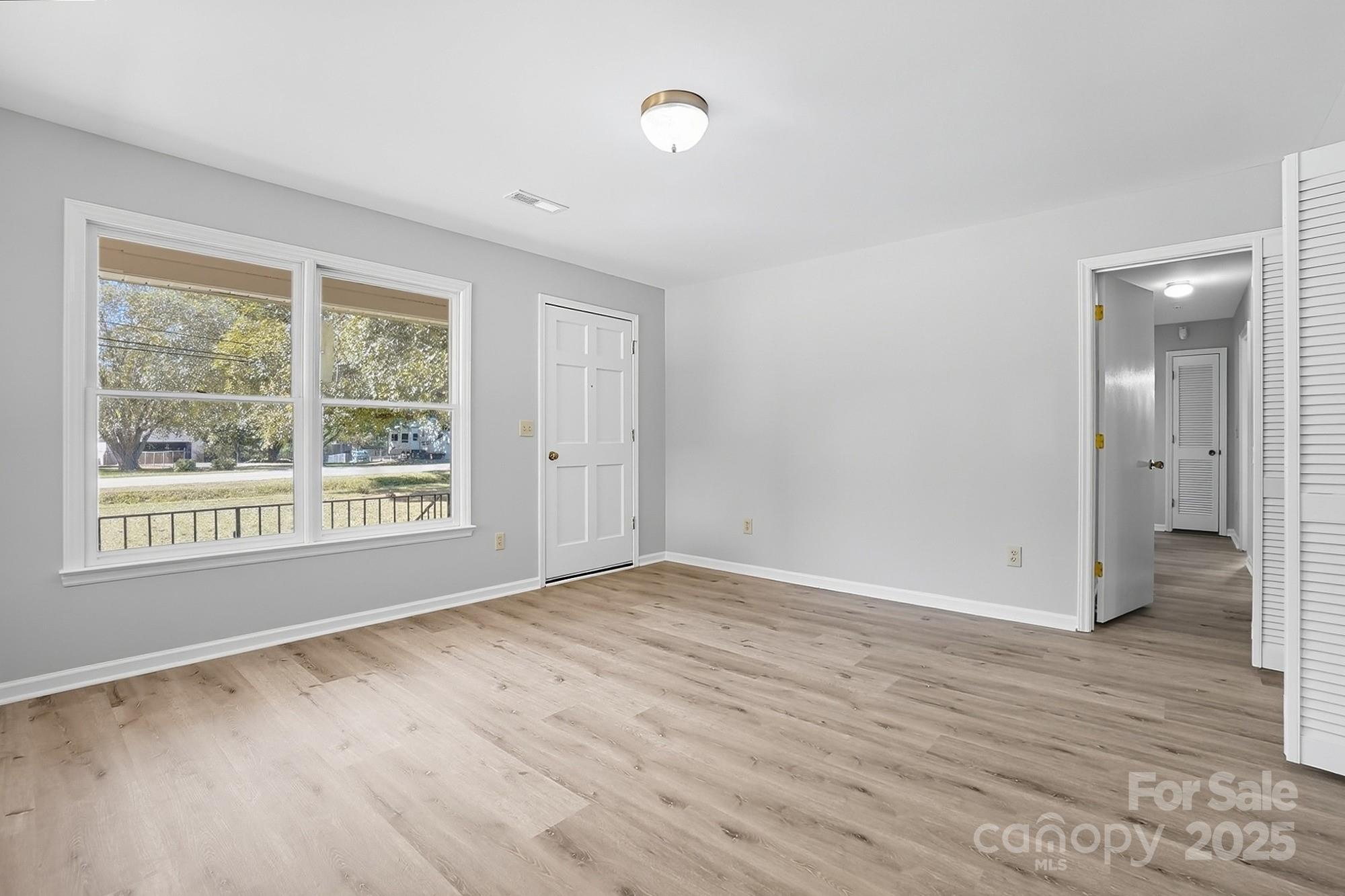 3230 West Innes Street Salisbury, NC 28144 - Photo 12 of 44 a view of an empty room with wooden floor and a window