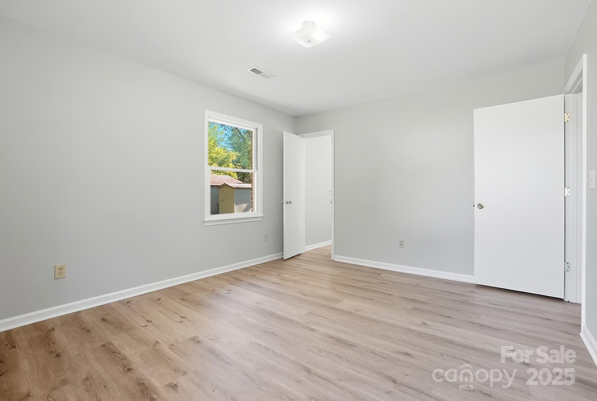 3230 West Innes Street Salisbury, NC 28144 - Photo 24 of 44 a view of an empty room with wooden floor and a window