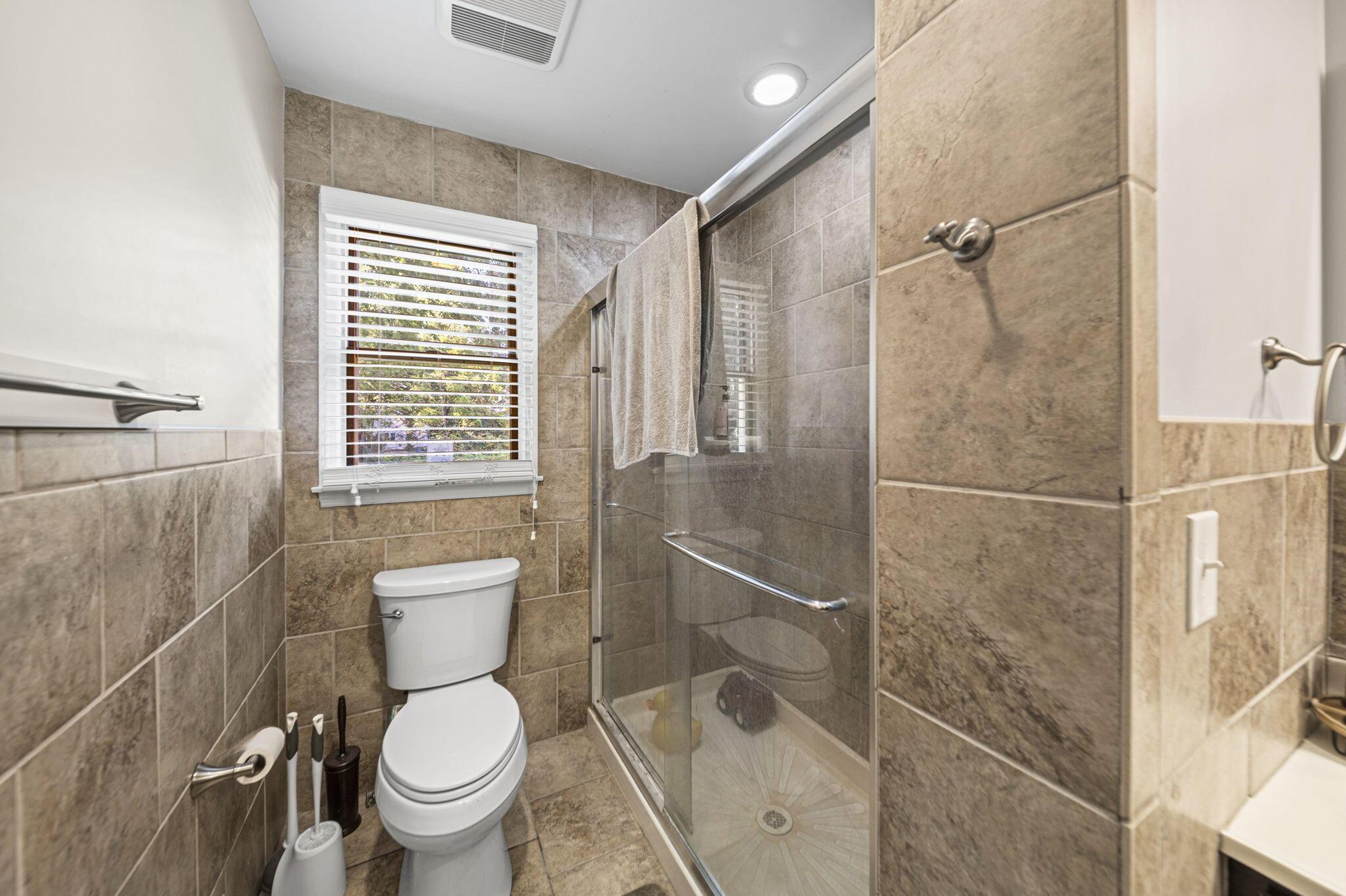 6344 Post Road Dublin, OH 43017 - Photo 24 of 45 Tiled shower enclosure with a glass door, recessed lighting, and a white toilet