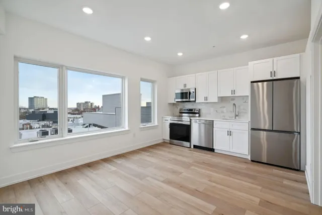 a kitchen with a refrigerator and a stove top oven