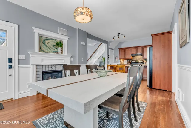 a kitchen with stainless steel appliances kitchen island granite countertop a stove a sink dishwasher and a refrigerator with wooden floor