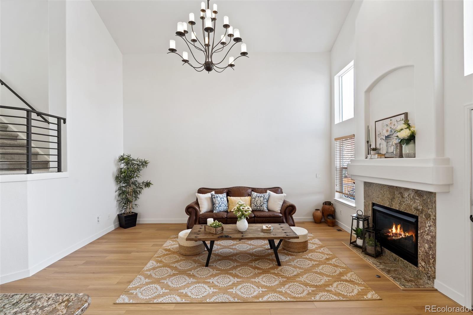 9838 Cypress Point Circle Lone Tree, CO 80124 - Photo 11 of 50 a living room with furniture a dining table and a fireplace