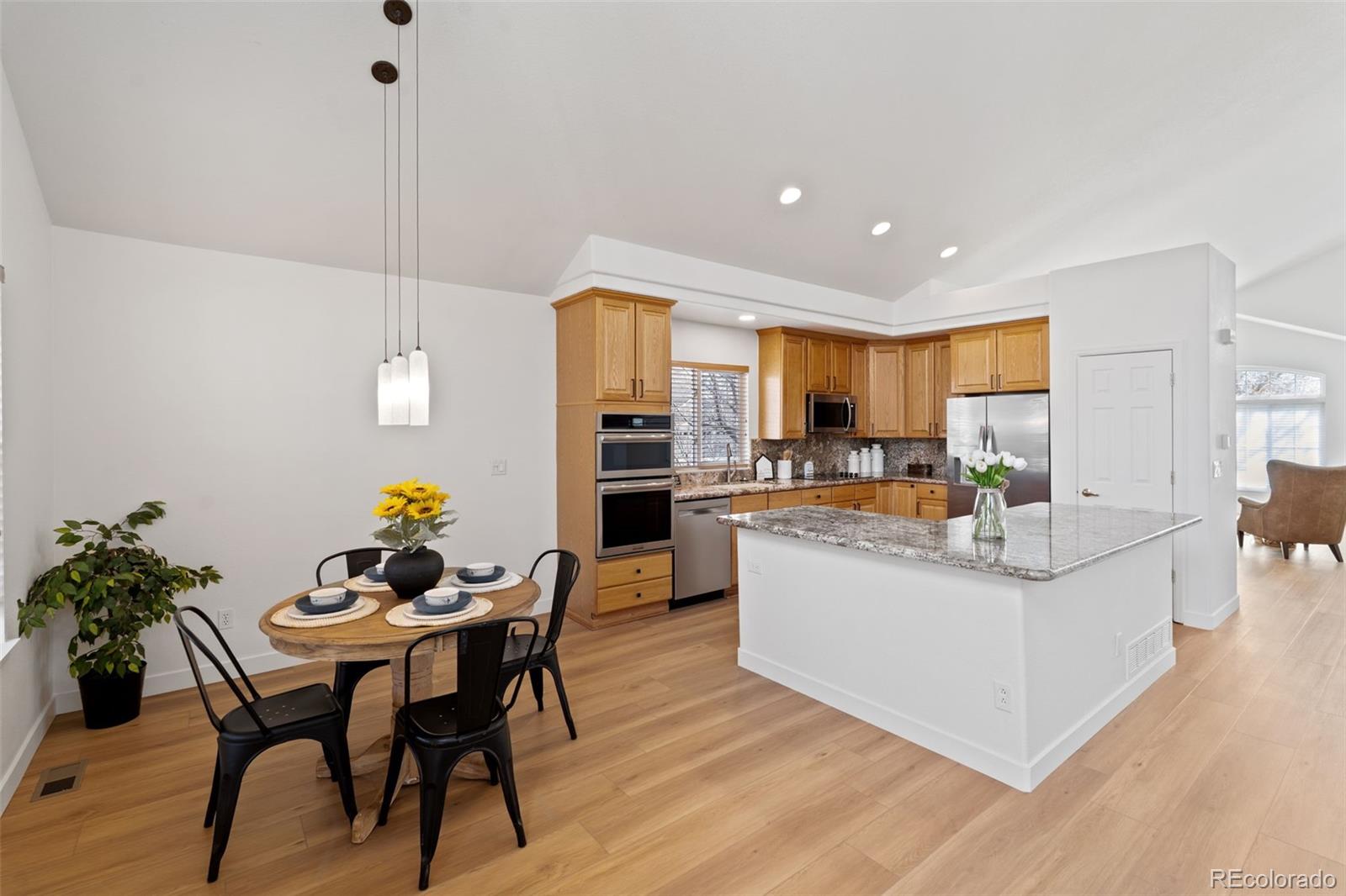 9838 Cypress Point Circle Lone Tree, CO 80124 - Photo 17 of 50 a living room with stainless steel appliances kitchen island granite countertop furniture and a wooden floor
