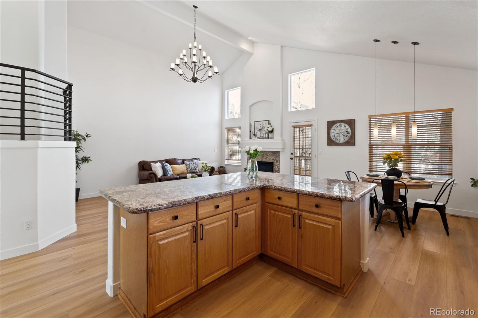 9838 Cypress Point Circle Lone Tree, CO 80124 - Photo 20 of 50 a kitchen with a sink chairs and wooden floor